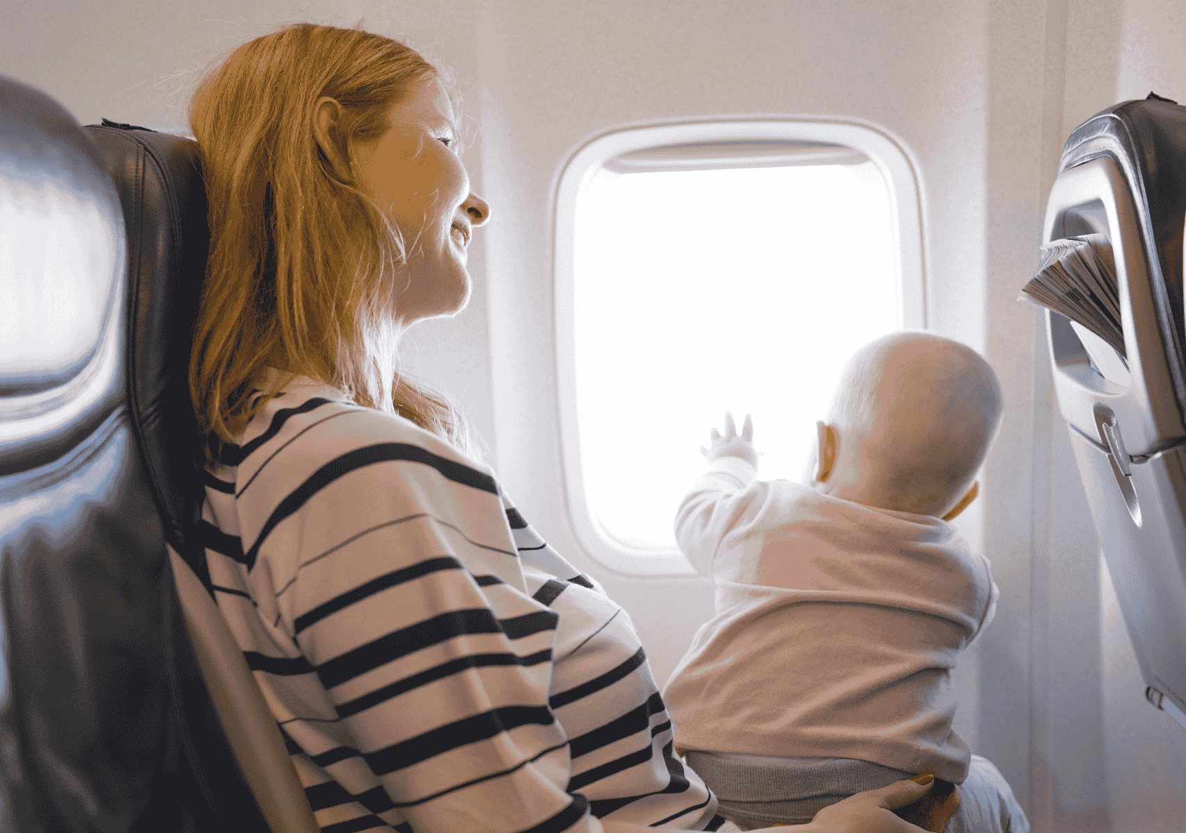 bebé viendo por la ventaja de un avión. A los cuántos meses puede viajar un bebé en avión